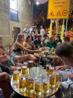 a group of people sitting around a table full of beer