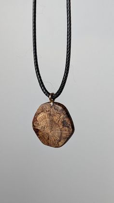 This is a handcrafted wooden pendant made from locally sourced and naturally fallen wood. This pendant features a beautiful and unique pattern caused by the natural decay of wood, as well as a hand sculpted design as a juxtaposition to the organic shapes of the spalting. The result is a timeless, breathtaking and organic piece of jewelry that suits women, men and children for almost any occasion or simply everyday life. I make these using only naturally fallen wood that I find on walks through m Brown Carved Round Pendant Necklace, Natural Carved Nature-inspired Necklace, Nature-inspired Carved Natural Necklace, Artisan Natural Wood Pendant Necklace, Rustic Natural Wood Necklace, Carved Natural Wood Necklaces, Natural Wood Pendant Necklace, Sliding Knot, Wooden Pendant