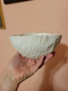 a person holding a white bowl in their hand