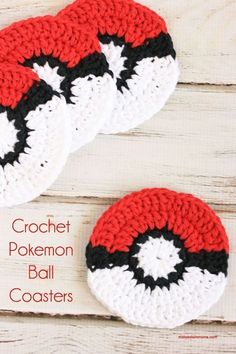 three crocheted pokemon ball coasters sitting on top of a white wooden table