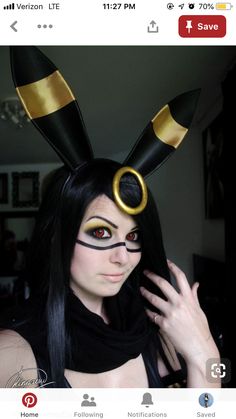 a woman with long black hair wearing a bunny ears costume and gold eyeliners