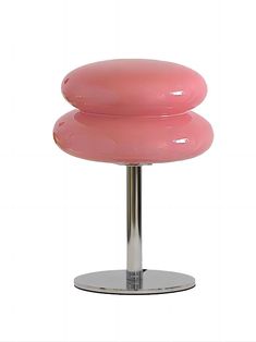 a pink stool sitting on top of a metal stand