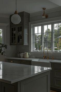 a kitchen with marble counter tops and an island in front of two windows that look out onto the yard