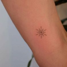 a small snowflake tattoo on the arm