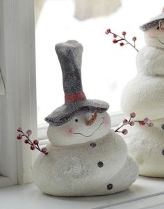 two snowmen are sitting on the windowsill