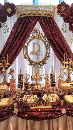 an elaborately decorated dessert table with red and gold decorations