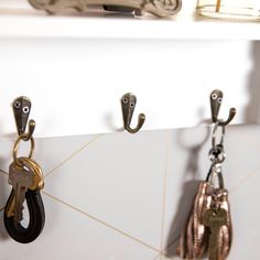 several keys are hanging on the wall with hooks