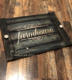 a sign that says farmhouse on it sitting on top of a wooden floor in front of a wood floor