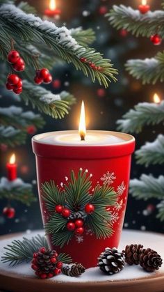 a lit candle sitting on top of a table next to pine cones and evergreen branches