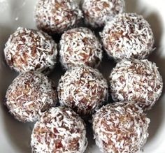 a white bowl filled with chocolate covered donuts