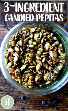 a glass jar filled with nuts on top of a wooden table