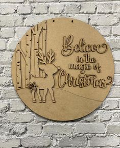 a wooden plaque with the words believe in the magic of christmas on it and a deer