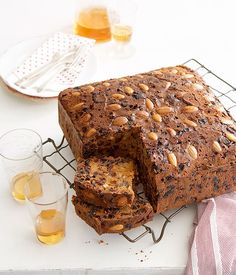 a loaf of bread sitting on top of a cooling rack next to two glasses filled with drinks