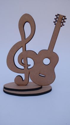 a wooden music note with a guitar on it's stand and a treble in the middle