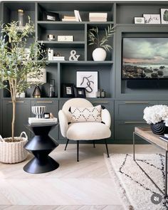 a living room filled with lots of furniture next to a wall covered in bookshelves