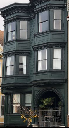 a large green house with many windows and balconies