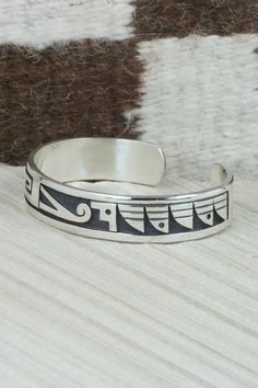 This sterling silver bracelet was made by Hopi silversmith Timothy Mowa. The inside is signed and stamped sterling.Size: 5 5/8" (will fit up to a 6 3/8" wrist)Gap: 3/4"Width: 1/2"Free shipping on all orders! We ship with USPS and always include tracking. All orders ship within a day of payment.Returns are accepted up to 30 days after you receive your order. Just send us a message. Our shop offers cash back or store credit. The item must be returned in new condition. Sterling Silver Bracelet, Native American Jewelry, Free Jewelry, Sterling Silver Bracelets, Cuff Bracelets, Silver Bracelet, Gap, Stamp, Bracelet