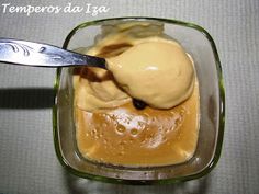 an ice cream dessert in a glass dish with a spoon on the side, topped with caramel sauce