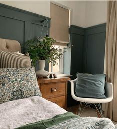 a bed room with a neatly made bed and a chair next to the window sill