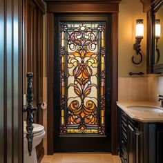 a bathroom with a stained glass door in the center and toilet on the other side