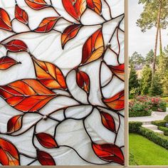 a stained glass window with red leaves on it