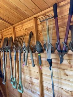 there are many garden tools hanging on the wall