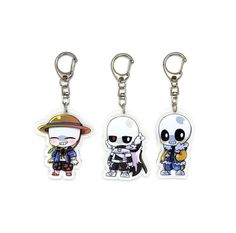 three different key chains with cartoon characters on them, one is white and the other is black