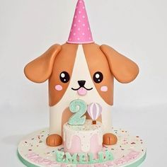 a birthday cake with a dog wearing a party hat on it's head and the number two candle in front of it