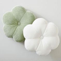 two green and white pillows sitting next to each other