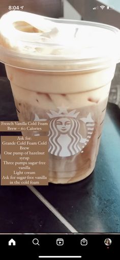 a cup of iced coffee sitting on top of a counter next to a cell phone