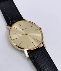 A fairly rare men's (unisex) 14k solid gold Swiss DUGENA watch with the classic Bauhaus look, with a gold punch on caseback, manual winding watch with a gold color dial, gorgeous, completely original, with lizard calf leather strap. The reverse is engraved, the watch is in good working condition, almost unworn pristine condition considering age, no scratches on the glass and case. Dates: 1979 Case size: 34 mm Total weight: approx. 29g A true classic, worth collecting! PLEASE NOTE: ALL MY WATCHES Antique Yellow Gold Watches For Business, Classic 14k Yellow Gold Watch, Gold Business Jewelry And Watches With Round Dial, Gold Jewelry And Watches With Round Dial For Business, Antique Gold Watch For Business, Classic Yellow Gold Analog Jewelry And Watches, Gold Engraved Business Watches, Engraved Gold Business Watches, Antique Yellow Gold Analog Watch