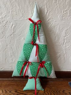 a green and white christmas tree sitting on top of a wooden table