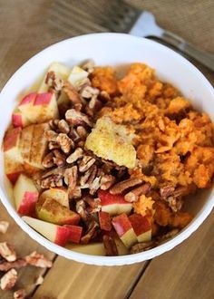 a bowl filled with fruit and nuts on top of a wooden table