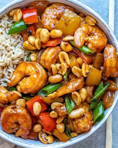 a bowl filled with rice, shrimp and veggies next to chopsticks