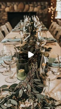 the table is set with wine glasses and place settings