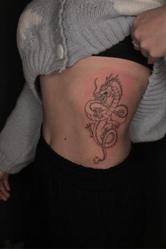 a woman with a dragon tattoo on her stomach