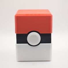 an orange and black box with a pokeball on it's lid sitting on a white surface