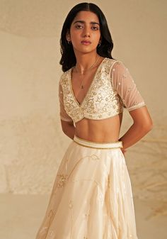 Featuring a beautiful cream lehenga made from shimmering metallic organza fabric, creating an ethereal glow. This elegant set comes with a matching blouse featuring delicate aari hand embroidery, adding a touch of intricate detail. A flowing silk organza dupatta completes the look, draped softly to highlight the outfit's timeless grace. Ideal for a reception at a destination wedding, this ensemble captures the heart with its simple beauty and elegance. Composition : Lehenga, Blouse, Dupatta - Organza Care: Dry Clean Only and Vacuum Storage This product can be customized for sleeves, length of blouse and neckline Delivery : 4-6 weeks as the product is hand crafted. Check Size Guide or choose MySize for free customisation (All Sizes above XL can be made at 15% additional cost) For more infor Cream Lehenga, Organza Lehenga, Desi Wear, Vacuum Storage, Ready To Wear Saree, Indian Wedding Wear, Lehenga Blouse, Elegant Sets, Organza Dupatta