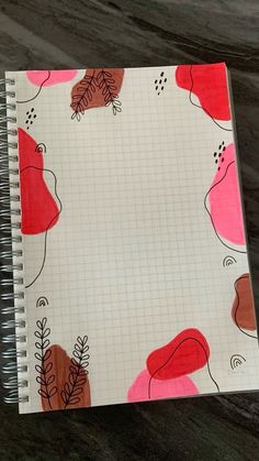 a spiral notebook with red and pink leaves on it