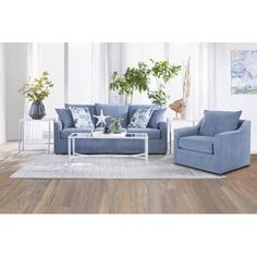 a living room with blue couches and white rugs on the wooden flooring