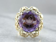 The center of this vintage gemstone is carved with the image of a maple leaf, shining from the center of the purple amethyst! We've set this gemstone into a filigree mounting that balances the unusual centerpiece perfectly! Metal: 14K Yellow Gold Gem: Amethyst 5.42 Carats Gem Measurements: 11.9 mm, Round Ring Size: 7 Oval Purple Filigree Amethyst Ring, Purple Oval Amethyst Ring With Filigree, Oval Purple Amethyst Ring With Filigree, Collectible Amethyst Ring, Antique Purple Amethyst Ring With Accent Stones, Formal Purple Amethyst Ring With Filigree, Collectible Purple Amethyst Ring With Center Stone, Purple Cabochon Amethyst Wedding Ring, Heirloom Amethyst Ring With Filigree