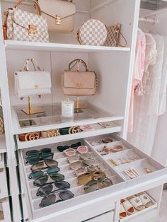 a white closet filled with lots of purses and handbags on top of shelves