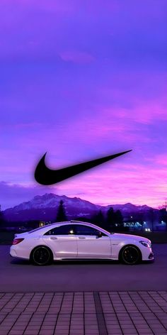 a white car parked in front of a purple sky