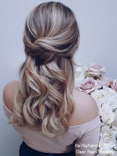 the back of a woman's head with long hair and flowers in front of her