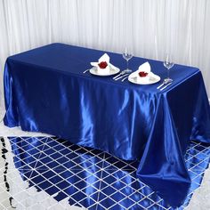 a blue table cloth with two white plates on it