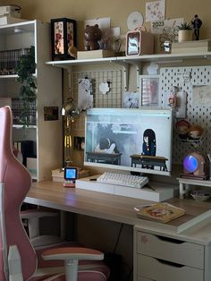 a desk with a computer monitor, keyboard and mouse next to a pink chair in front of it