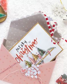 an open envelope with christmas cards on top of it next to some cookies and other holiday decorations