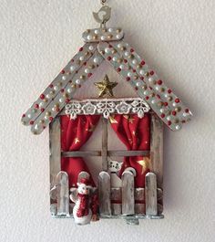 a christmas ornament hanging from the side of a building with red and white decorations