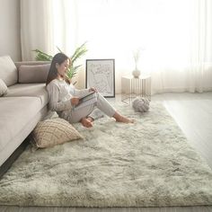 a woman sitting on the floor reading a book