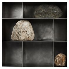 some rocks are sitting in a black shelf